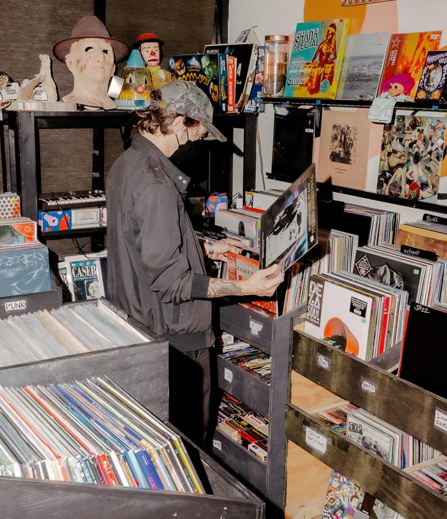 A customer browsing vinyl records at Graveface Records and Curiosities