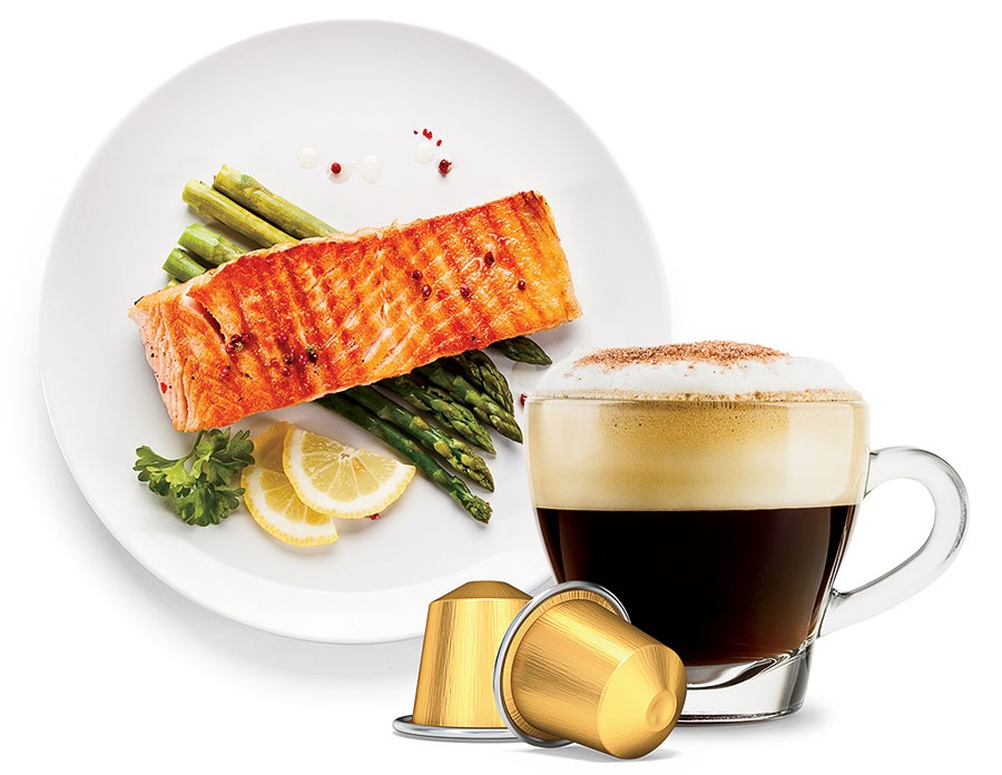 A plate of salmon and asparagus, a cappuccino, and coffee pods