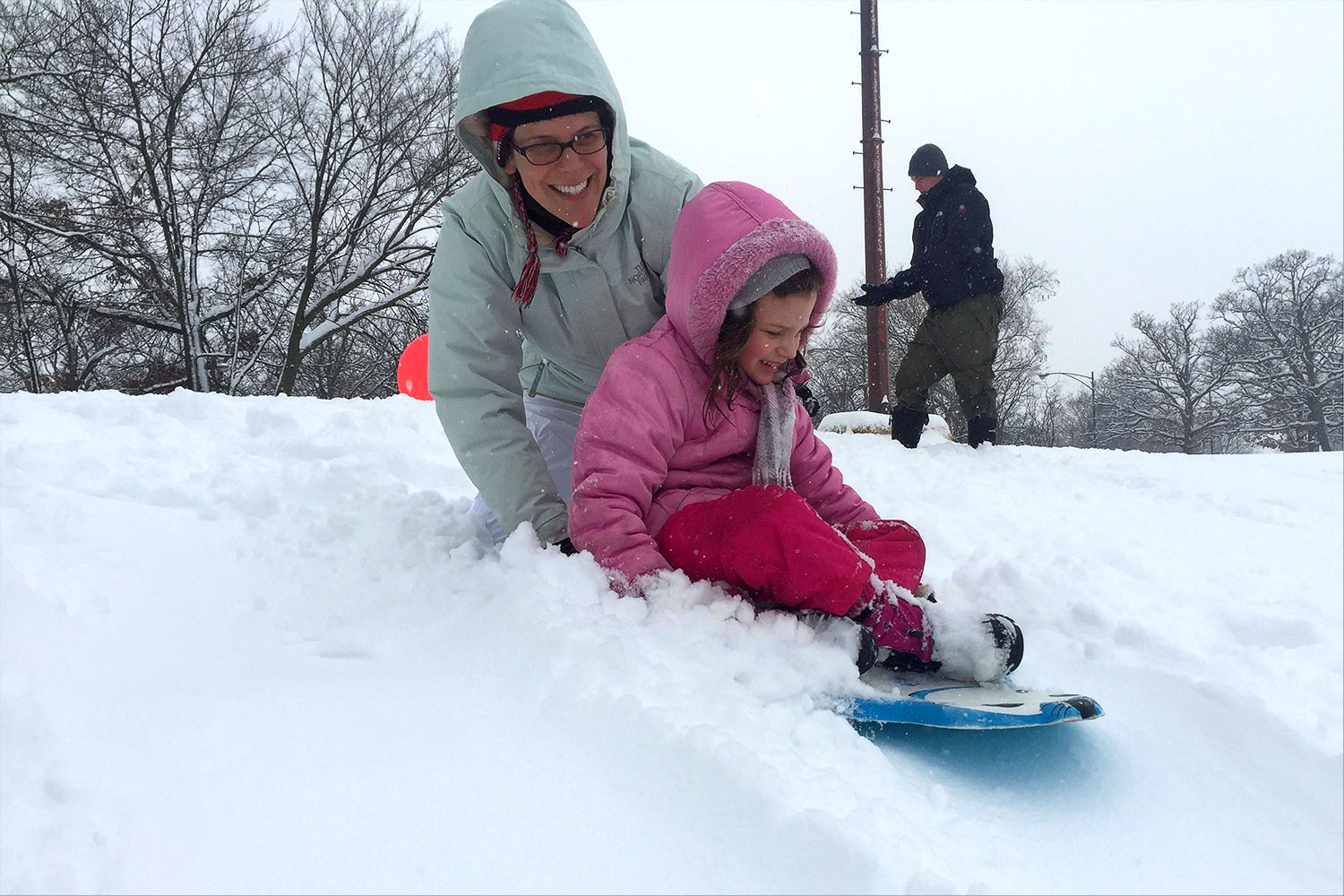 A mother and child sledding at Dan Ryan Woods